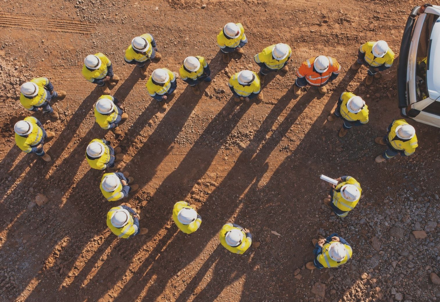 A crew gathered for a pre-start meeting, seen from above